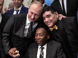 El presidente ruso, Vladimir Putin, toma de la mano a Pelé y del cuello a Maradona, dos de las máximas figuras que ha dado el futbol. AFP/A. Nikolsky
