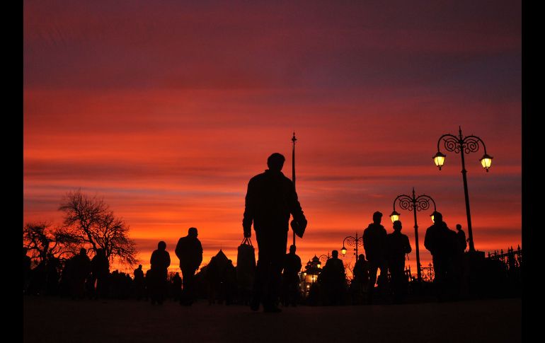 Usuarios del transporte caminan en la población india de Shimla al atardecer. AFP