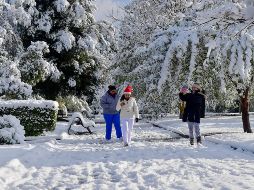 Un grupo de personas camina por un parque cubierto de nieve en Monclova, Coahuila. EFE / M. Sierra