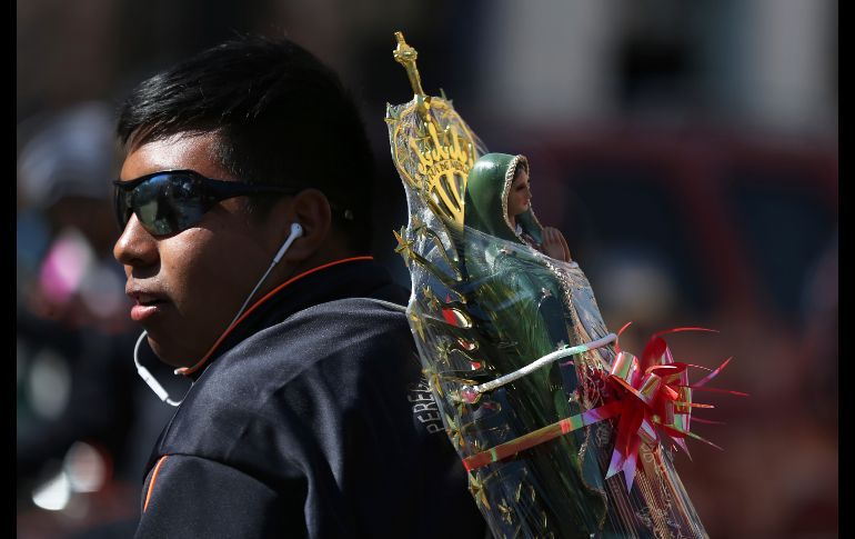 Un peregrino carga una imagen de la Virgen de Guadalupe.