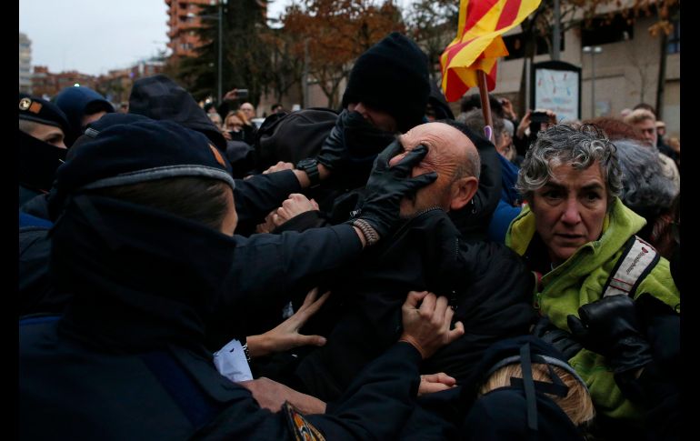 Oficiales de la policía catalana se enfrentan con manifestantes en el museo Lleida en Cataluña, España, en una protesta contra la decisión judicial que ordena al museo a devolver 44 piezas de arte al gobierno vecino de Aragón. AP/M. Fernández