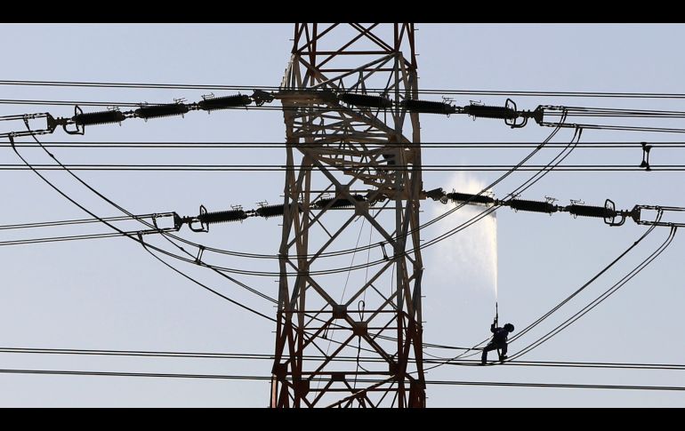 Un trabajador da mantenimiento a cables de electricidad en la ciudad de Kuwait. AFP/Y. Al-Zayyat