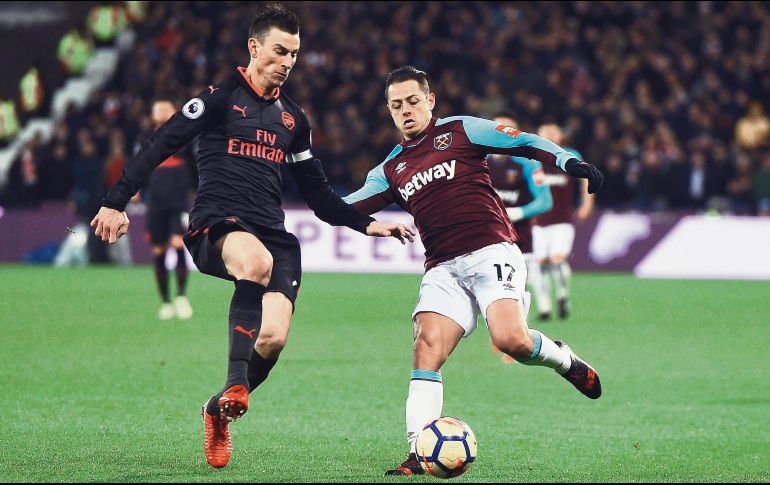 Javier “Chicharito” Hernández (derecha), quien disputa el balón con Laurent Koscielny, del Arsenal, estuvo a punto de poner el gol que hubiera significado el triunfo para el West Ham en la Premier League. EFE