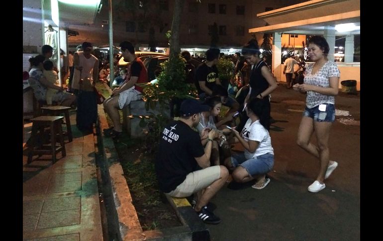 Habitantes aguardan en una calle de Yakarta luego de evacurar un edificio de departamentos.