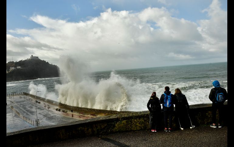 Personas observan grandes olas que se estrellan en una barrera de protección en San Sebastián, España. Una tormenta en la región deja fuertes vientos y lluvias. AP/A. Barrientos