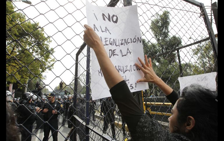 Un participante coloca un cartel sobre una reja.