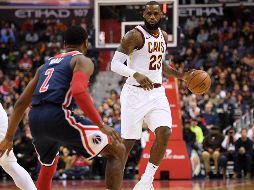 LeBron James. Luciendo unos zapatos especiales, el astro de los Cavaliers intenta encestar ante la marca de Jodie Meeks y Mike Scott (#30), de los Wizards. AP
