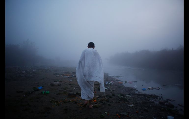 Un hombre camina hacia el río Bagmati en Katmandú, Nepal, para realizar un ritual del festival 
