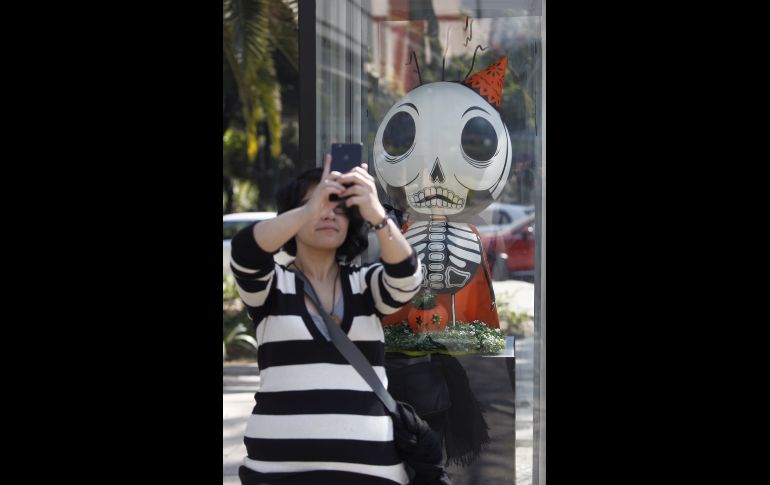 Una mujer toma una foto junto a la figura 