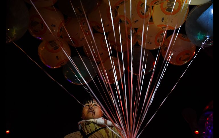 Un vendedor ofrece globos en forma del robot BB-8 de 