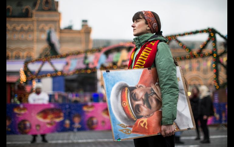 Una artista lleva un retrato del ex líder soviético Josef Stalin afuera de una tienda del Departamento de Estado, en la plaza Roja de Moscú, Rusia. Simpatizantes del comunismo conmemoraron el natalicio de Stalin. AP/A. Zemlianichenko