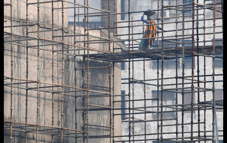 TOPSHOTS - TOPSHOT - An Indian labourer works on a construction site during heavy smog conditions in New Delhi on December 21, 2017. / AFP / Dominique Faget TOPSHOTS-TOPSHOT-INDIA-ENVIRONMENT-POLLUTION-SMOG
