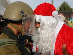 Un hombre palestino vestido de Santa Claus discute con un soldado israelí en Jerusalén. AP / N. Shivoukhi