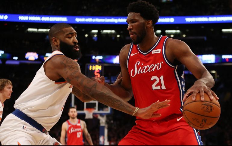 Joel Embiid (#21) intenta burlar la marca de Kyle O'Quinn. AFP/M. Stobe