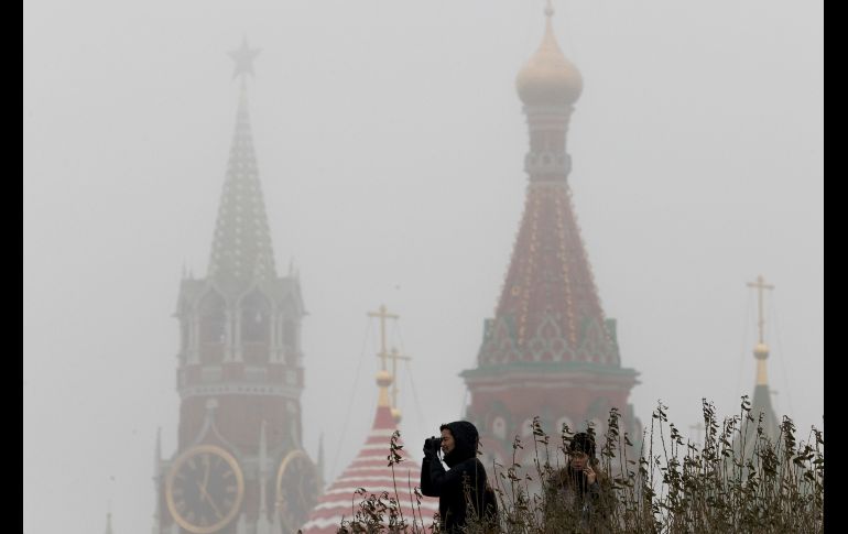 Turistas chinos toman fotos cerca de la plaza Roja, mientras se registra neblina en Moscú, Rusia. AP/I. Sekretarev
