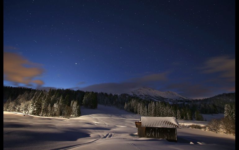 Un cielo estrellado se ve sobre un paisaje nevado en Unterjoch, Alemania, antes del amanecer. AFP/DPA/K. Hildenbrand