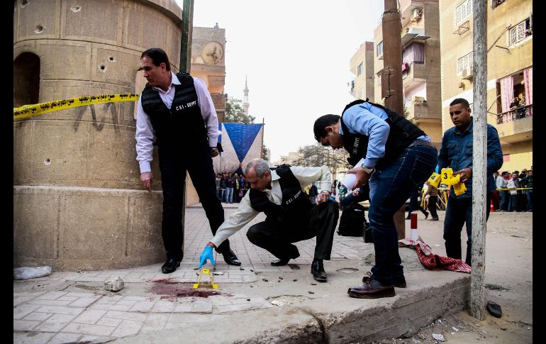 Forenses egipcios inspeccionan el sitio de un tiroteo afuera de un templo al sur de El Cairo. Un hombre armado abrió fuego y mató a por lo menos nueve personas. AFP/S. Abdallah
