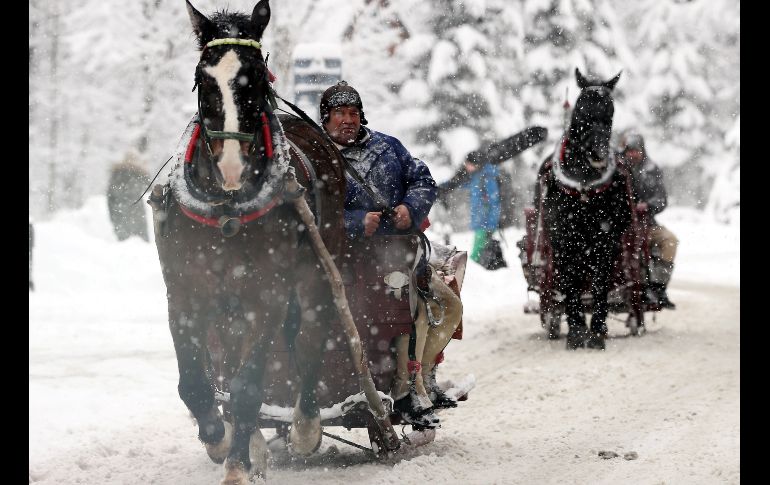 Varios trineos recorren una calle durante una fuerte nevada en Zakopane, en el sur de Polonia. EFE/ G. Momot