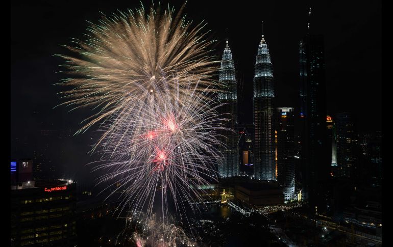 Fuegos artificiales junto a las torres Petronas de Kuala Lumpur, en Malasia, marcan el Año Nuevo.