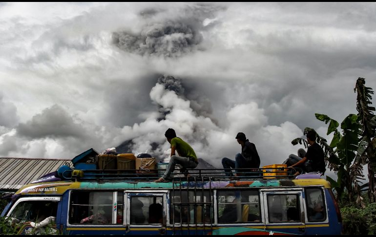 Pasajeros de un camión observan el volcán Sinabung que arroja una columna de ceniza en Karo, Indonesia. AFP/I. Damanik
