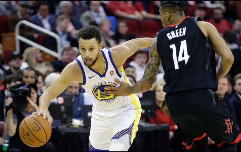 La estrella Stephen Curry conduce el balón ante la marca de Gerald Green (#14), de los Rockets, durante el juego de ayer. AP/D. Phillip
