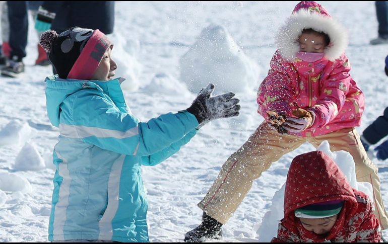 Varios niños juegan en medio de la nieve en una de las comunidades afectadas por el temporal. EFE/YONHAP