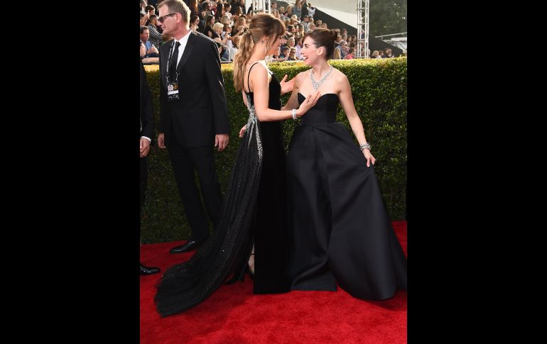 Dakota Johnson y Alison Brie se saludan.