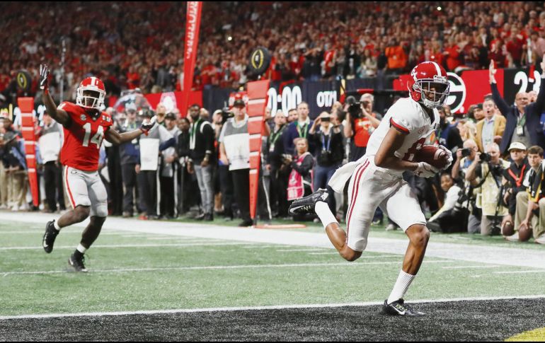 En el terreno. DeVonta Smith (der.) anota en tiempo extra para la victoria de Alabama. AP/D. Goldman
