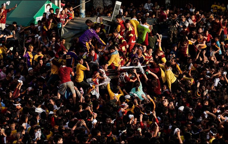 Devotos filipinos intentan alcanzar la imagen del Nazareno Negro durante la multitudinaria procesión que se celebra cada 9 de enero. EFE/R. Cristino