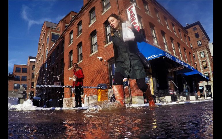 Una joven camina en un charco de nieve derretida en Portland, en el estado de Maine, luego de que las temperaturas subieron por arriba de los cero grados centígrados. AP/R. F. Bukaty