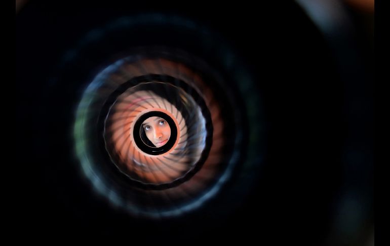 Un estudiante mira a traves de un lanzador de cohetes en un colegio de Chennai, India, en el marco de una celebración del Día de la Armada. AFP/A. Sankar