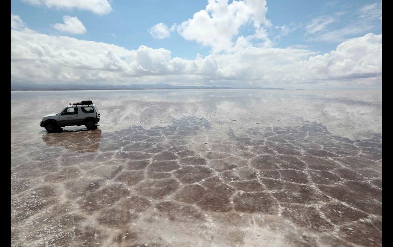 Una camioneta circula por el salar de Uyuni, Bolivia, tras las intensas lluvias de la noche, lo que provoca el famoso 