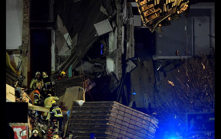 Bomberos inspeccionan el edificio colapsado.