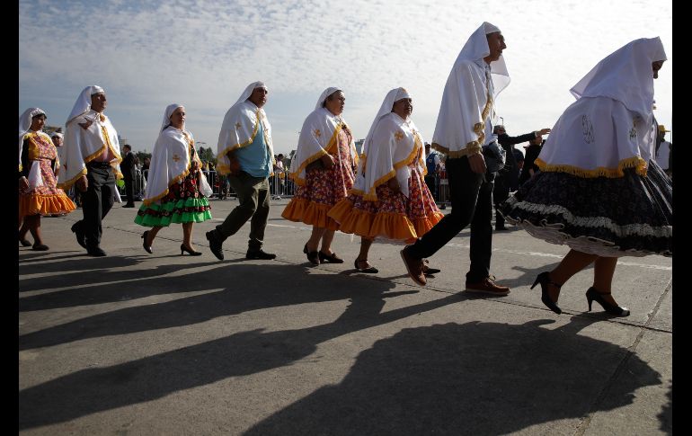 Habitantes en atuendo tradicional llegan para la misa campal en el centro de Santiago.