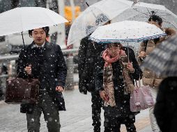 Varias personas transitan por una calle de Tokio en medio de una nevada. AFP/B. Mehri