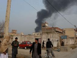 Varios vehículos estacionados frente a la oficina de la ONG resultaron afectados y se encuentran en llamas, por lo que una gran columna de humo se puede ver a distancia. AFP/N. Shirzada