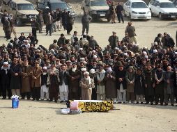 Varias personas rezan durante el funeral de una de las víctimas de la explosión. AP/R. Gul