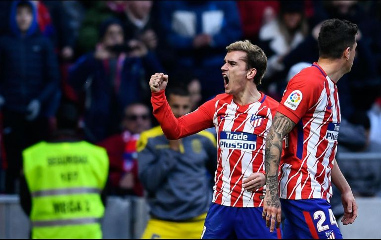 El francés Antoine Griezmann (I) celebra tras abrir el marcador para los Colchoneros. AFP/O. del Pozo