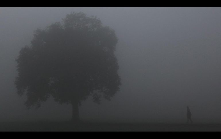 Un habitante camina por un campo en Jammu, India, en una mañana con densa neblina. AFP/R. Bakshi