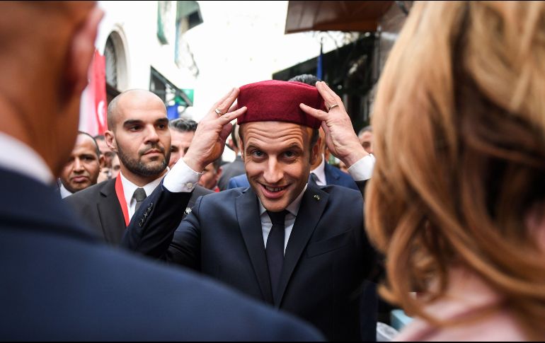 El presidente francés Emmanuel Macron se prueba un fez durante un recorrido por la medina de la ciudad de Túnez. Macron realiza una visita oficial a Túnez. AFP/E. Feferberg