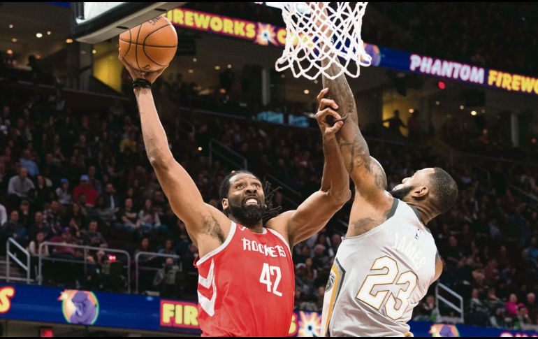 Superados. Nene Hilario (#42), de los Rockets, intenta encestar ante la marca de LeBron James, de los Cavaliers. AFP