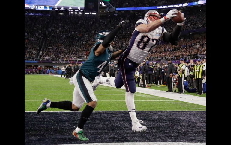 Gronkowski (d) atrapa un pase para touchdown junto a Ronald Darby (i) para el 32-33 a favor de los Patriots.