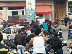 En una imagen de las protestas se puede apreciar que algunos manifestantes bajan llantas de una patrulla. ESPECIAL