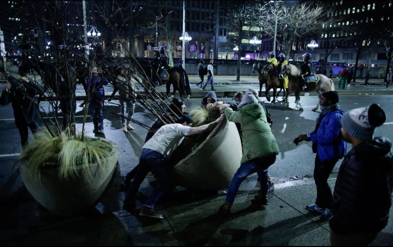 En algunos puntos, los aficionados treparon a postes públicos y destruyeron cuanto encontraron a su paso. AFP / E. Munoz
