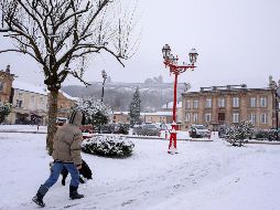 Un hombre camina por una plaza cubierta por la nieve en Montmedy, al norte de Francia. EFE/J. Warnand