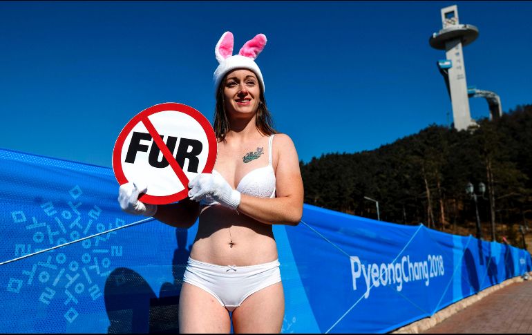 Una activista de la organización PETA protesta contra el uso de pieles de animales junto a un anuncio de los Juegos Olímpicos de Invierno en Pyeongchang, Corea del Sur. AFP/D. Dilkoff