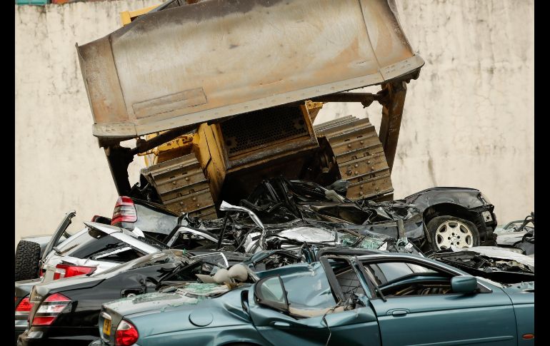 Una excavadora destruye coches de lujo decomisados, durante una ceremonia en Manila, Filipinas. EFE/ M. R. Cristino