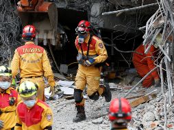 Varios miembros de los servicios de rescate salen de un edificio en ruinas. EFE/B. Tongo