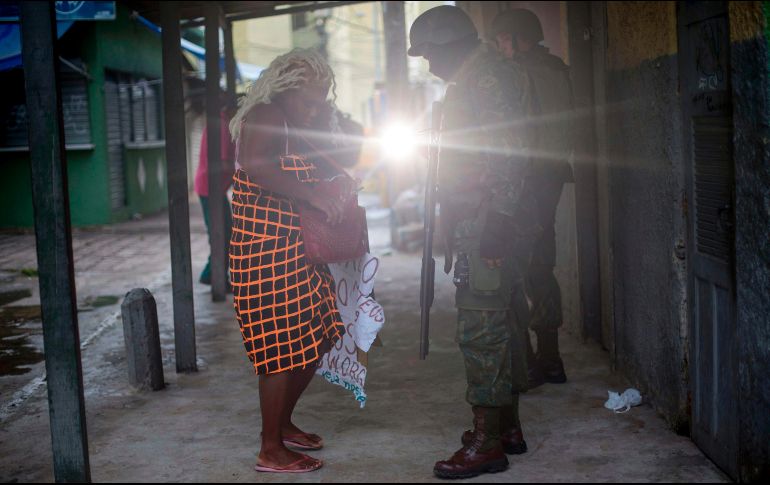 Soldados revisan a una vecina de la favela 