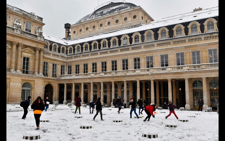 Algunos recibieron con entusiasmo la inusual capa de nieve. Personas juegan en el jardín del Palacio Real.